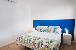 普拉亚布兰卡Blancazul Tegala的一间卧室配有一张白色大床和蓝色床头板