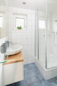 诺德奈Fewo Grete的白色的浴室设有水槽和淋浴。