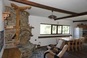 KameshtitsaКъща за гости "Касапите"的客厅设有石制壁炉和桌子。