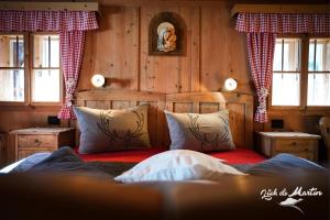 拉瓦莱Lüch de Martin的卧室配有一张床铺,位于带木墙的房间内