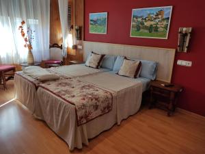 沙比纳尼哥艾斯卡廷旅馆的一间卧室设有一张带红色墙壁的大床