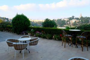 耶路撒冷St Andrews Guest House的一个带桌椅的庭院,享有城市美景