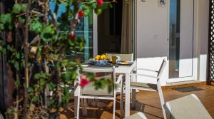 卡武埃鲁Panoramic Seaview Holiday Escape Carvoeiro Algarve的桌子和椅子上放着一碗水果