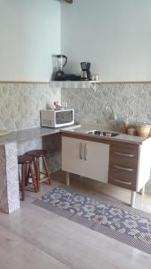 伊利亚贝拉Chalé e suite Manu的厨房配有水槽和微波炉