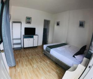 班塔延岛Paradise Beach Guest House的一间小卧室,配有一张床和电视