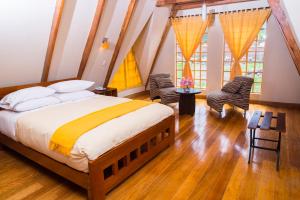 乌鲁班巴阿马鲁山谷酒店的一间卧室配有一张大床和两把椅子