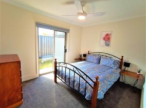 奥尔伯里My Abode in Albury的一间卧室配有一张带蓝色棉被的床和窗户。