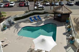 玛志洛皇家城堡海滩度假酒店的享有带椅子和遮阳伞的游泳池的顶部景致