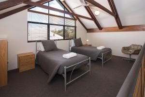 邓斯伯勒邓斯伯勒海滩小屋度假酒店的阁楼间 - 带两张床和窗户