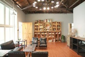台南麦克阿舍的一间设有图书室的房间,配有椅子和书架