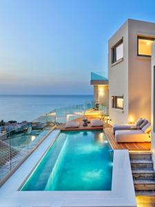 普拉塔尼亚斯Alectrona Living Crete, RocSea Luxury Apartment的一座带游泳池和大海的房子