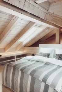 诺恩威格Lieblingsort - Cosy Black Forest Chalets的木制天花板的客房内的一张大床