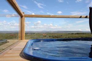雷克霍特Blue View Cabin 1A With private hot tub的甲板上的热水浴缸,设有大窗户