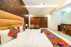 博帕尔FabHotel Prime President- Near to Bhopal Airport的酒店客房配有一张带彩色枕头的大床