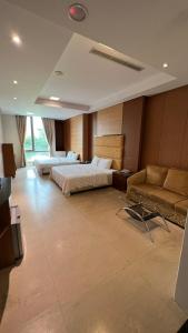花莲市采盈精品休闲旅馆的酒店客房,设有两张床和一张沙发