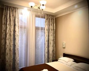 乌日霍罗德阿特兰特酒店的一间卧室配有床和带窗帘的窗户