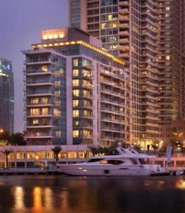 迪拜努然玛丽娜服务公寓的大型建筑前的水中小船