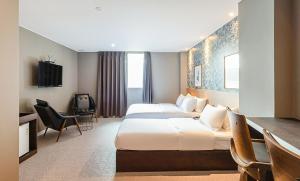 釜山No. 25 Signature Hotel Daecheong的酒店客房配有两张床和一张书桌