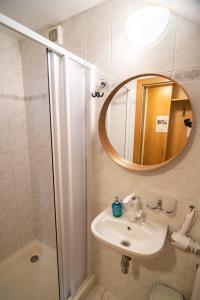 米库洛夫Apartmán a ubytování U Machů的一间带水槽、镜子和淋浴的浴室