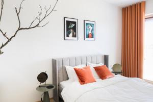塔林Kadriorg Plaza 2 bedroom FREE Parking的一间卧室配有带橙色枕头的床