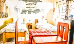 内罗毕Furnishedapartments的一间设有两张床、一张桌子和一张长凳的房间