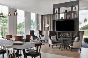 嘉兴贝慕尼黑Stellaris Apartment Hotel的客厅配有桌椅和电视。