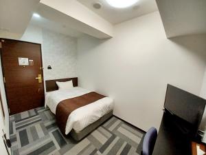 东京Akasaka Urban Hotel Annex的一间小卧室,配有一张床和电视