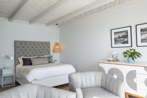 普林格尔贝伊Villa Marine Guest House的白色卧室配有床和椅子