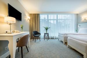 维尔纽斯拉顿达中心酒店的配有一张床和一张书桌的酒店客房