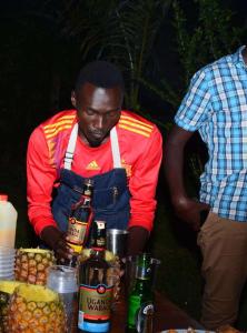 MbaleSipi Valley Resort的男人站在桌子旁边喝着饮料