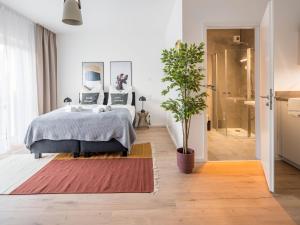 美因河畔法兰克福limehome Frankfurt Gutleutstraße - Digital Access的一间卧室配有一张床和盆栽植物