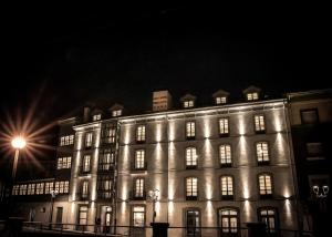 San Esteban de PraviaGran hotel Brillante的一座大建筑晚上点亮,灯光照亮