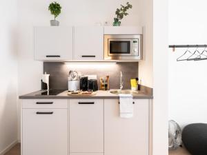 美因河畔法兰克福limehome Frankfurt Gutleutstraße - Digital Access的厨房配有白色橱柜和微波炉