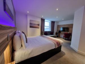 巴罗弗内斯Escape Hotel的酒店客房,配有一张紫色照明床