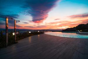 奥尔比亚Hotel dP Olbia - Sardinia的一条带水池的走道上的日落