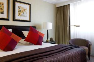 巴黎巴黎华威酒店（原香榭丽舍华威酒店）的配有红色枕头的床的酒店客房
