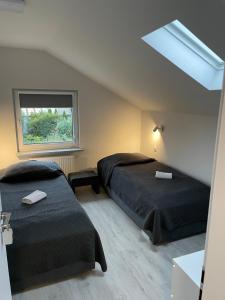 科莫尔尼基科莫尔尼基裴森酒店的一间卧室设有两张床和窗户。