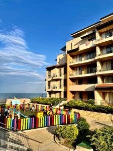 奥布佐尔Obzor Beach Resort的海滩旁一座带五颜六色围栏的建筑