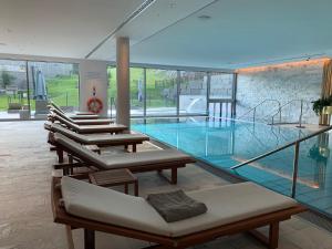 达沃斯Alpen panorama luxury apartment with exclusive access to 5 star hotel facilities的大楼内带躺椅的大型游泳池