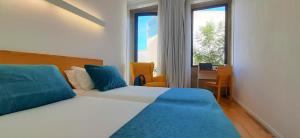 波尔图博维斯塔住宿加早餐旅馆的一间卧室配有一张床、一张书桌和一个窗户。