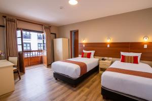 库斯科Hotel San Pedro Plaza的酒店客房设有两张床和一个阳台。