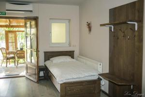 PăulişPensiunea Dulce Ambient的一间卧室设有一张床,并有通往庭院的门