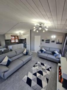 Warton4 Bed Luxury Lodge with Hot tub near Lake District的带沙发和 ⁇ 格地板的客厅