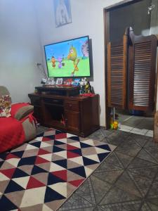 阿帕雷西达CANTINHO VOLTE SEMPRE的一间带电视和 ⁇ 格地板的客厅
