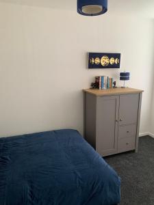 DalmuirThe Cochno Flat, Clydebank的一间卧室配有一张床和一张带蓝毯的书桌
