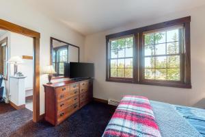 格兰比Bluebird Skies的一间卧室配有梳妆台、电视和窗户。