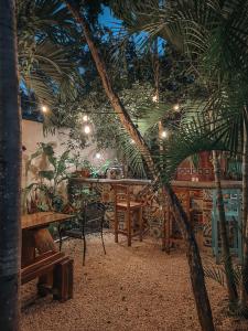 图卢姆Trece Lunas Tulum - Adults Only Enchanted Resort的一间设有桌子和棕榈树的餐厅
