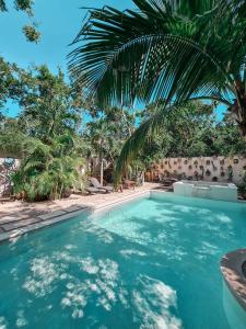 图卢姆Trece Lunas Tulum - Adults Only Enchanted Resort的一座拥有蓝色海水和棕榈树的游泳池