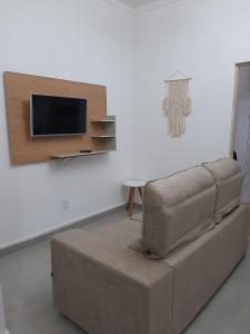 卡波布里奥Apartamento Confortável Perto da Praia的客厅配有沙发和墙上的电视