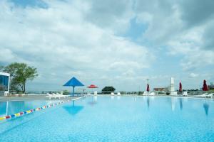 邦美蜀Elephants Hotel的一个带椅子和遮阳伞的大型游泳池